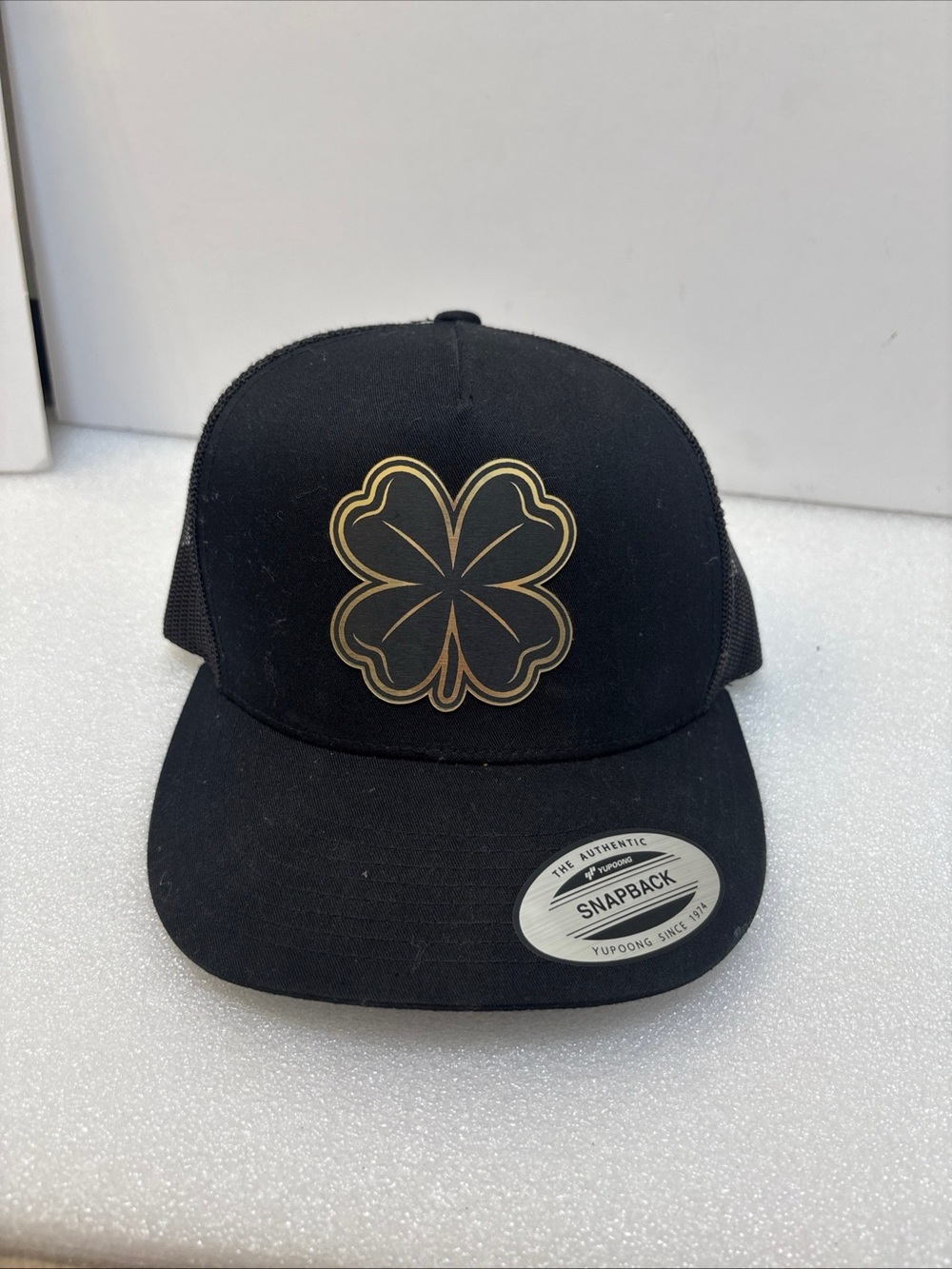The Classic Black Mesh Trucker Hat with Gold Logo Patch
